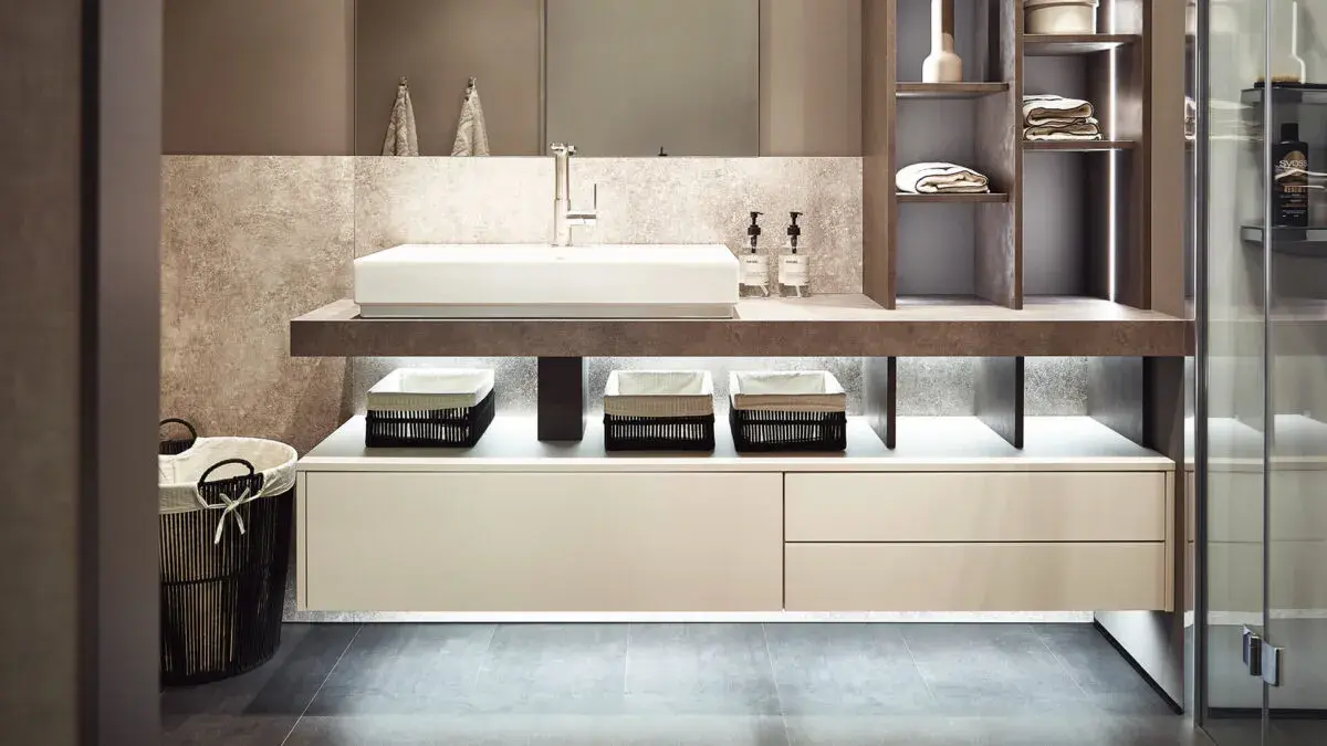 Modernes Badezimmer mit Waschbecken, Regalen, Handtüchern und dezentem Licht.