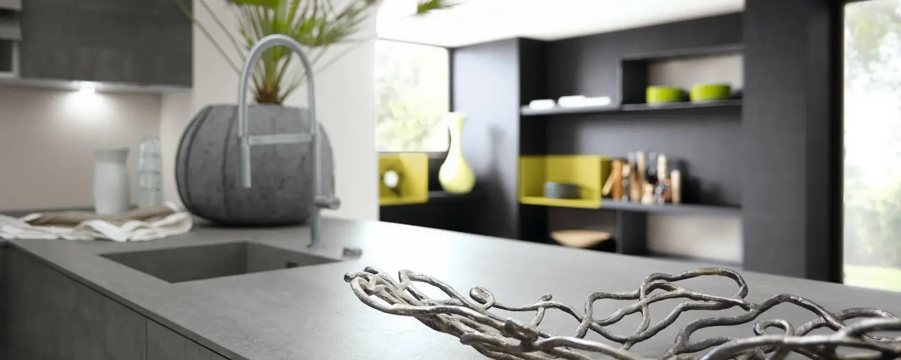 Ansicht einer Kücheninsel mit Arbeitsplatte in der eine Spüle integriert ist. 